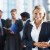 Cute business woman with colleagues in discussion at the background